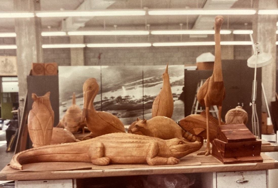 Table of wooden alligator, birds, fish, and small mammals