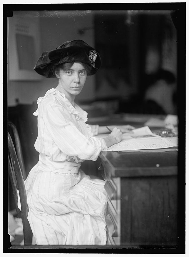 Woman sitting at desk looking at the camera.