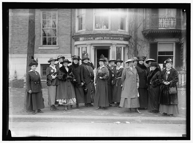 Suffragists in front of Cameron House, which served as the group headquarters. (1917) A group of women stand in front of suffragist headquarters.