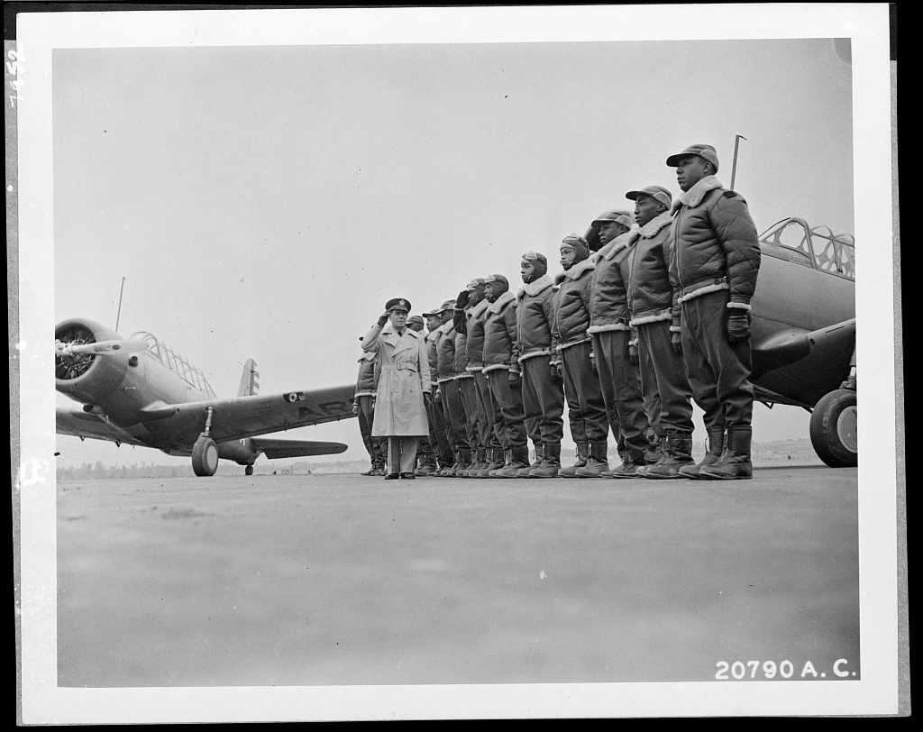 Some of the cadets at the Basic and Advanced Flying School for Negro Air Corps Cadets are shown here, January 23, 1942, lined up for review with Major James A. Ellison returning the salute of Mac Ross of Dayton, Ohio, as he inspects the cadets. Cadets lines up for review with Major Ellison returning a salute