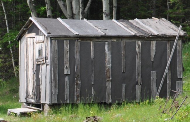 Historical paper shack with vertical wooden boards.