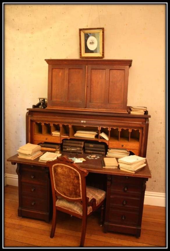 snuggery4 a writing desk with a small bookcase attached at the top with a chair that is pulled out for someone to sit