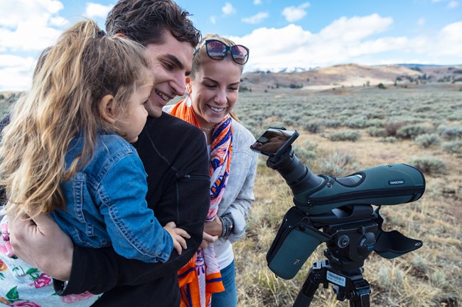 family uses a spotting scope to watch wildlife