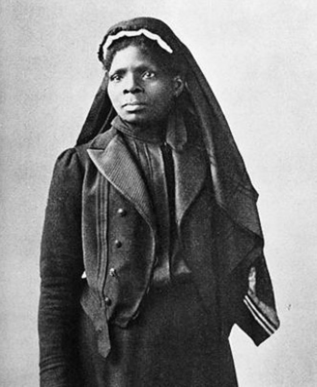 Susie K. Taylor Black and white image of women of color standing wearing vail headwear