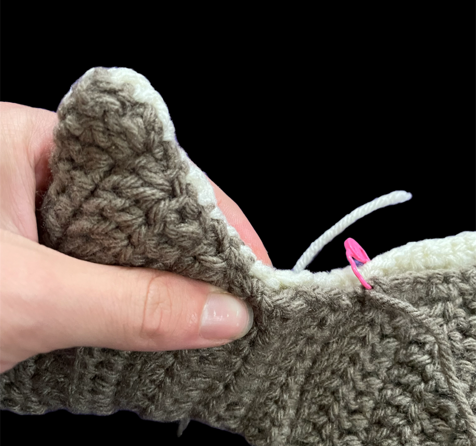 Close up of the tail on a crocheted halibut fish.