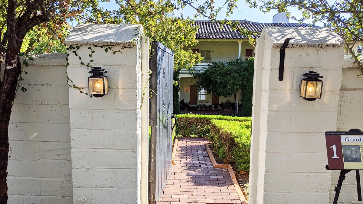 white brick wall with door open leading to house and lawn