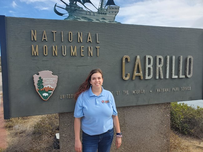 woman posting in front of Cabrillo National Monument's sign