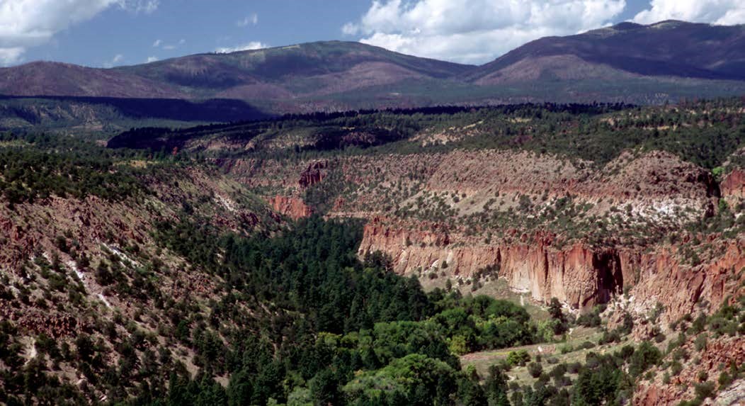 photo of semi arid landscape with cliffs and low rounded mountains