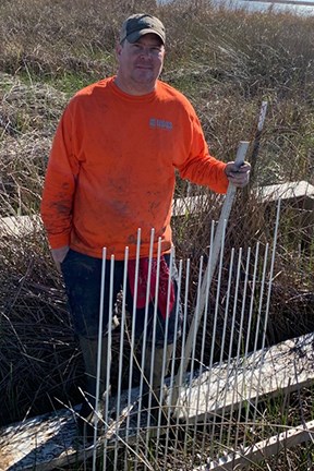 Ches Vervaeke, USGS Ecologist man on a platform in a marsh