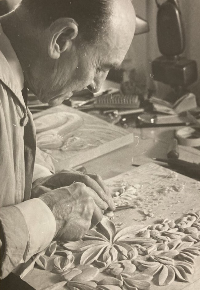 John Segeren carving a floral pattern into a piece of wood.