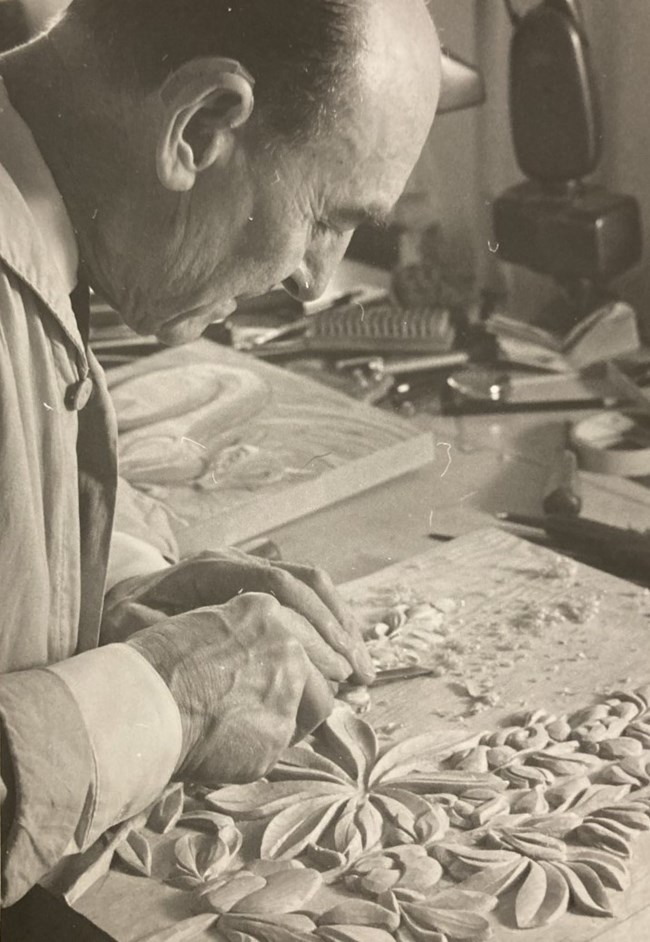 John Segeren at work carving flowers. John Segeren carving a floral pattern into a piece of wood.