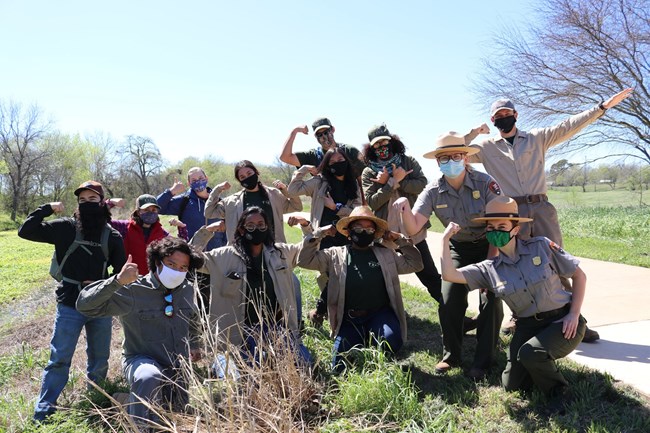 TXCC Interns and Park Rangers flex their muscles for a group photo outdoors.