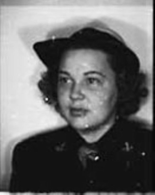 Sue Unger Eskey Black and white portrait of Sue Unger Eskey, a young woman with dark curly hair. She is wearing a hat with a brim and a dark blouse. She looks to the right of the camera with a neutral expression