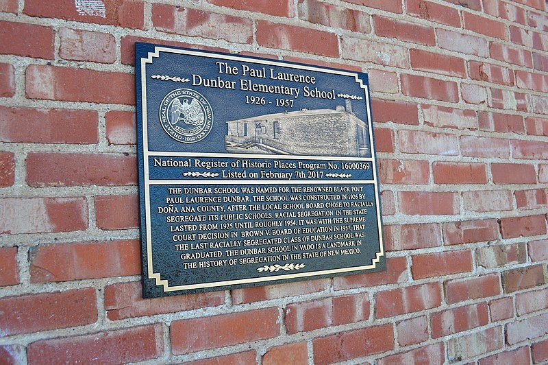 A bronze plaque on a red brick building.