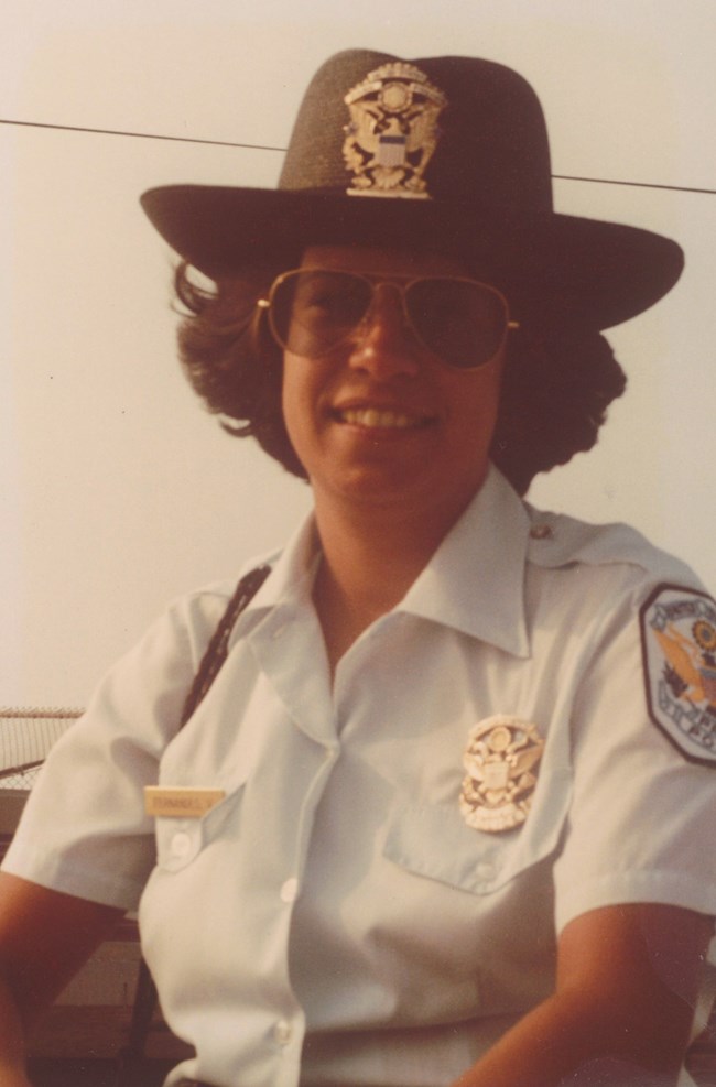 Officer Valerie Fernandes in uniform with a black straw hat