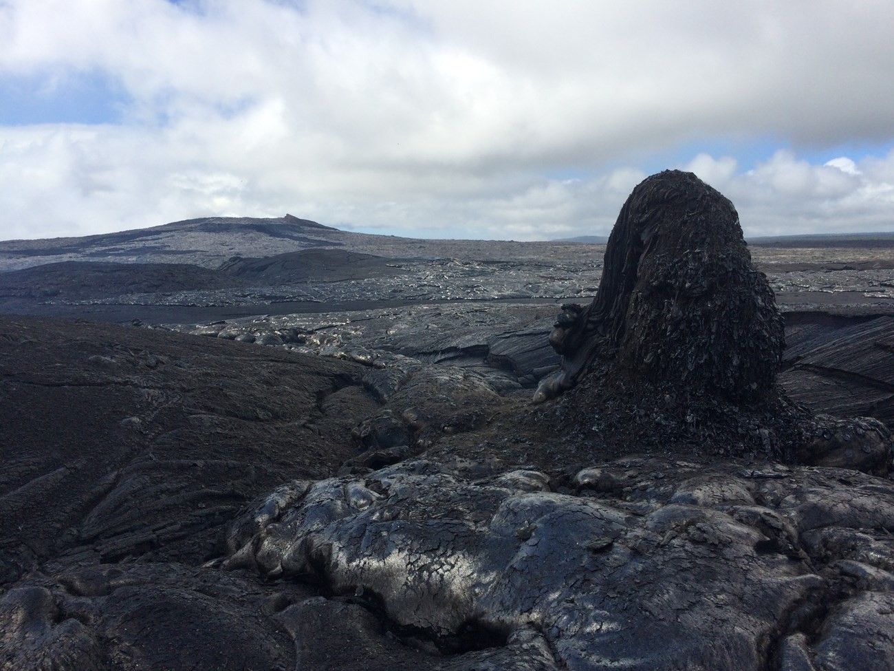photo of tall rock outcrop and surrounding volcanic landscape