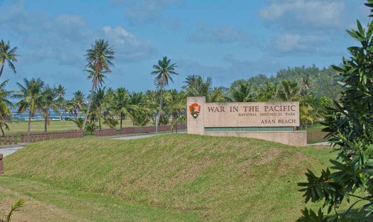 War in the Pacific National Historic Park welcome sign sits behind a green grassy hill