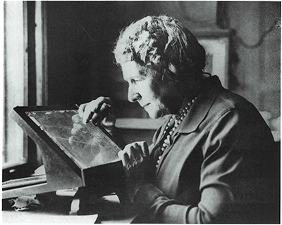 web Annie Jump Cannon Image credit Harvard-Smithsonian Center for Astrophysics A woman examines a photographic plates of the night sky.
