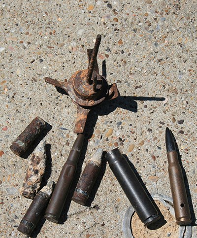 several shells and bomb parts on a concrete surface