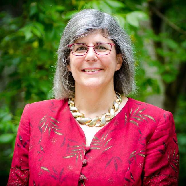 close up of woman standing in a forested area