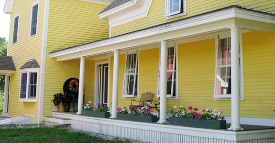 wooden-storm-windows yellow house with wood storm windows