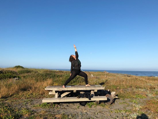 yoga550 woman doing yoga pose on a park bench outside