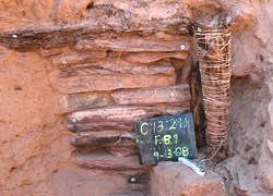 The wooden post next to a masonry wall. Close up of the red masonry wall with a wooden post to the right.