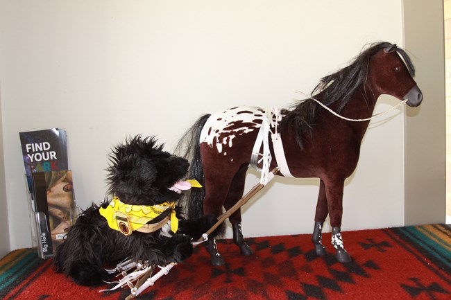 toy dog riding on a travois