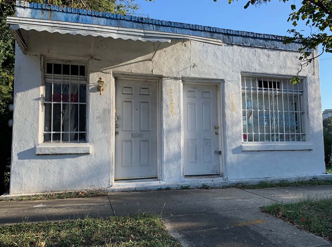 Rectangular, small, single story, hollow concrete block commercial building with a brick veneer foundation.