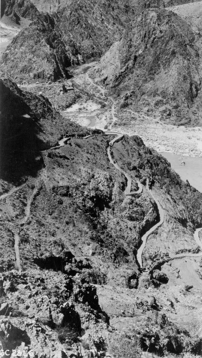 Ariel view of trails running down a rocky landscape to the river.