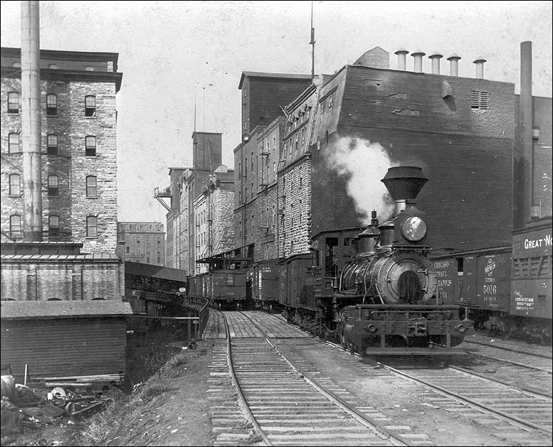 Photo of West Side Milling District, Minneapolis, ca. 1890 depicting brick buildings and steam engine on a track. (Minnesota Historical Society, photographer unknown) Photo of West Side Milling District, Minneapolis, ca. 1890 depicting brick buildings and steam engine on a track. (Minnesota Historical Society, photographer unknown)