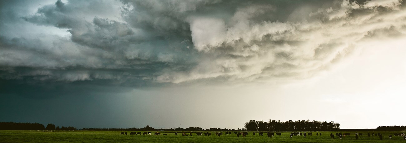 Dark storm clouds gathering over fields. Dark storm clouds gathering over fields.
