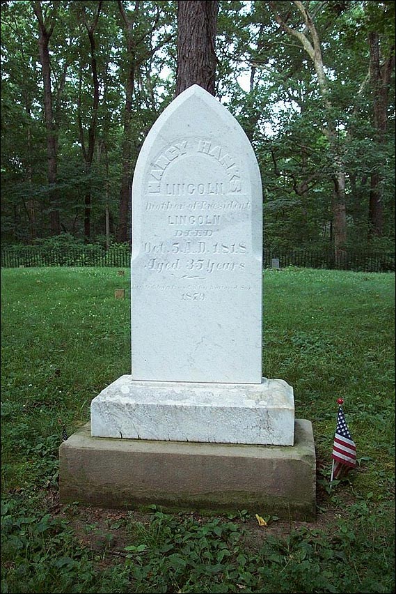 Headstone with a small American flag staked in the ground. (National Park Service)