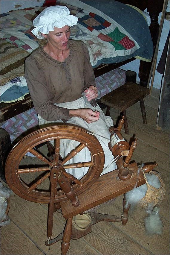 Woman spinning wool on a spinning wheel. National Park Service.
