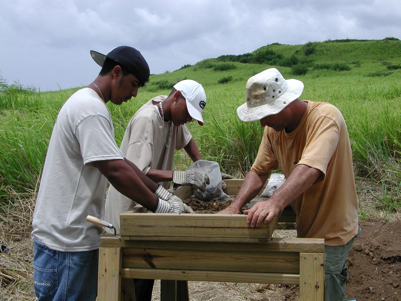 SEAC archeologist and YCC interns screening soil for artifacts