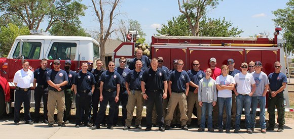 Firefighters in front of a structural fire engine.