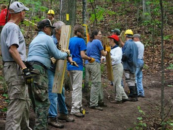 Group of trail workers carrying equipment