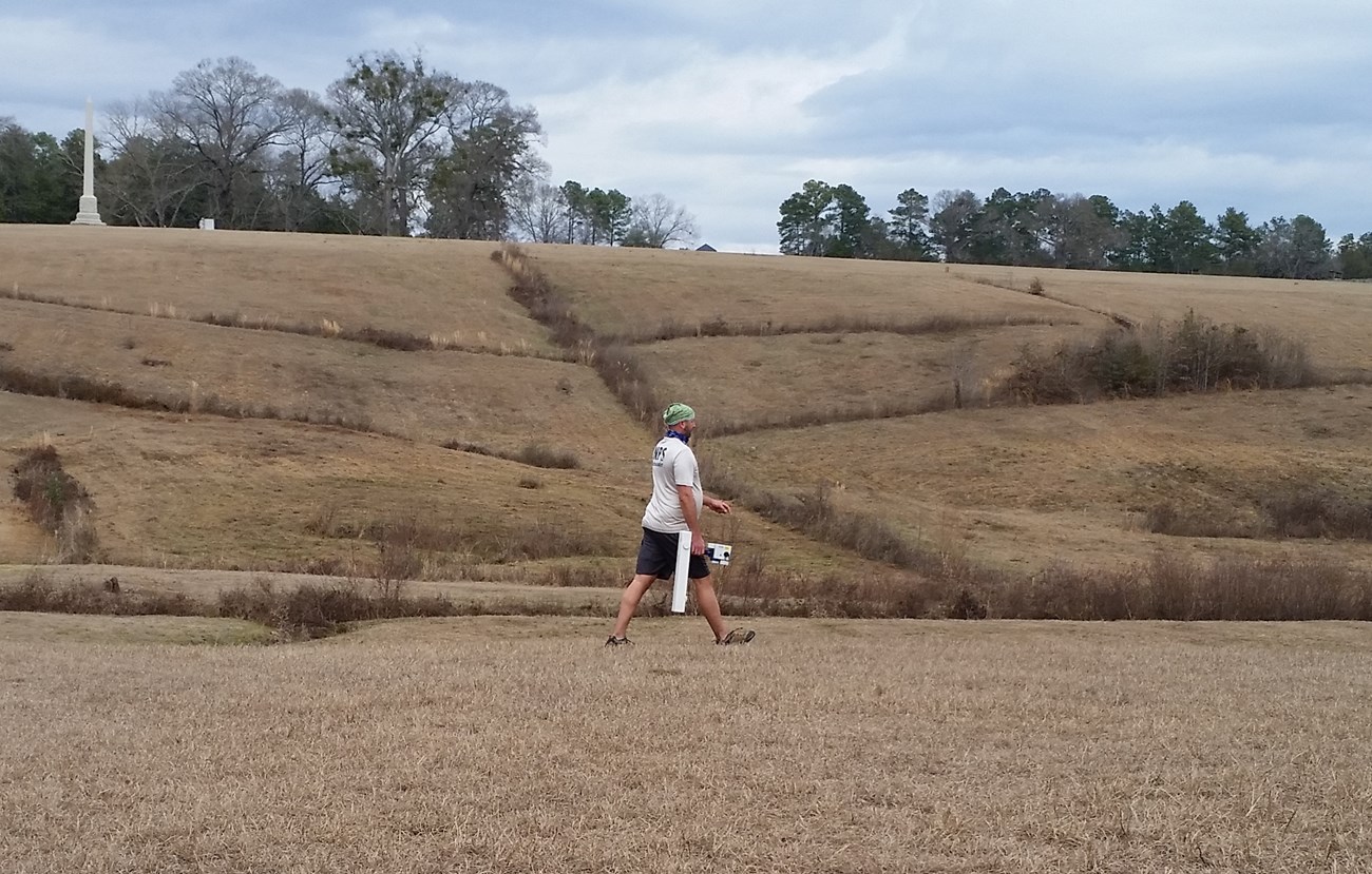 Archeologist Eric Bezemek uses a magnetometer on the south slope of Andersonville prison. Archeologist Eric Bezemek uses a magnetometer on the south slope of Andersonville prison.