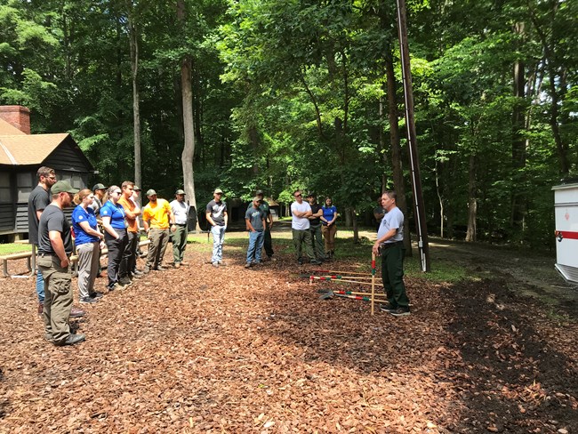 2019 Wildfire Outdoor Lecture in Prince William Forest Park Trainees listen to instructor speak about handtools near fire engine.