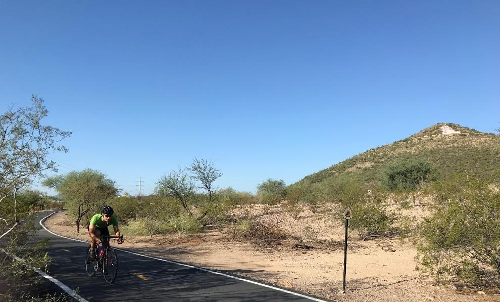 A cyclist takes an early morning ride in Santa Cruz River Park on “The Loop,” a pedestrian and bike path which safely connects different parts of Tucson. Photo courtesy of Kendra Barat, National Park Service. A cyclist takes an early morning ride in Santa Cruz River Park on “The Loop,” a pedestrian and bike path which safely connects different parts of Tucson. Photo courtesy of Kendra Barat, National Park Service.