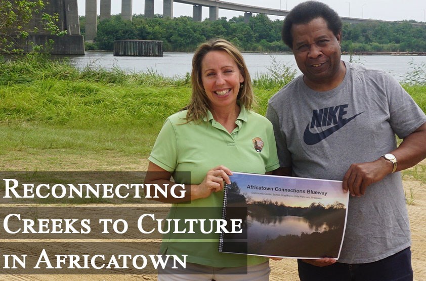 Smith-Incer and Womack hold the Mississippi State University concept plan under the Cochrane Africatown USA Bridge, where the Clotilda first landed. Photo by Margaret Gach, National Park Service.