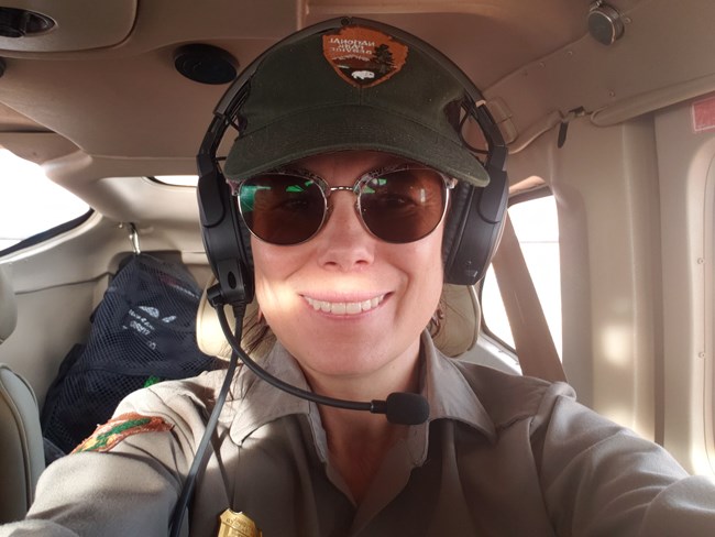 Persons selfie with airplane headset on. They are sitting in a small plane.