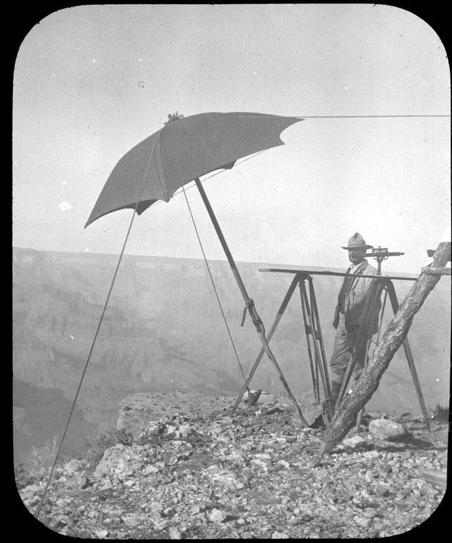 A pioneer stands next to an umbrella-shaped structure on the rim. A pioneer stands next to an umbrella-shaped structure on the rim.