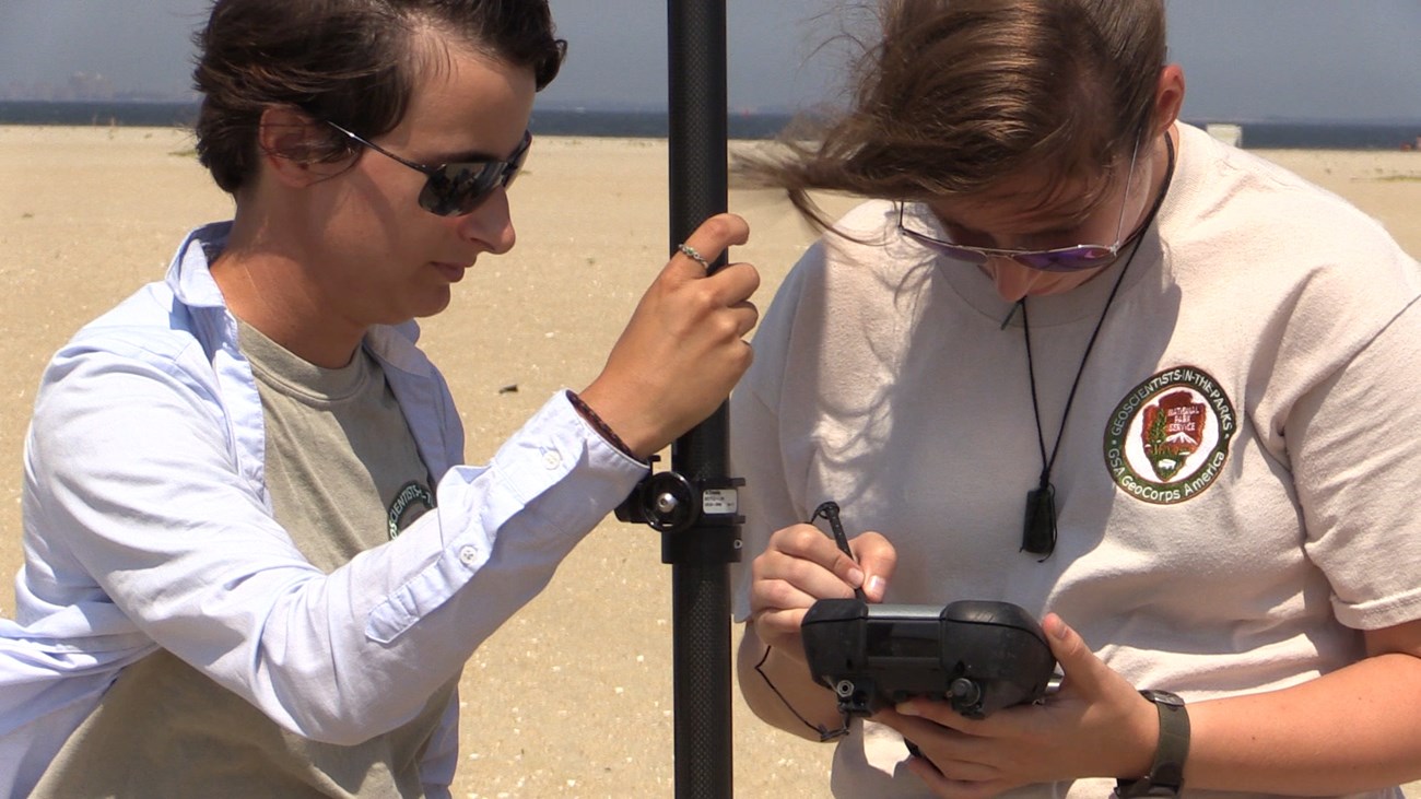 lt= Katy Ames (right) records data with another GIP Intern while working with cooperators from Rutgers University on a Geomorphologic Mapping project looking at changes to landform features as a result of Hurricane Sandy