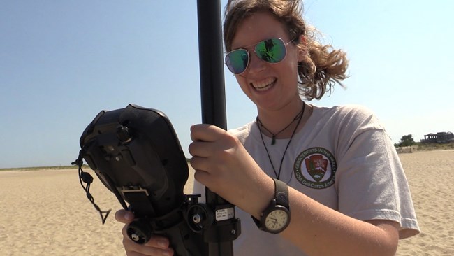 lt= Katy Ames, GeoCorps Intern, 2015, stands on a beach