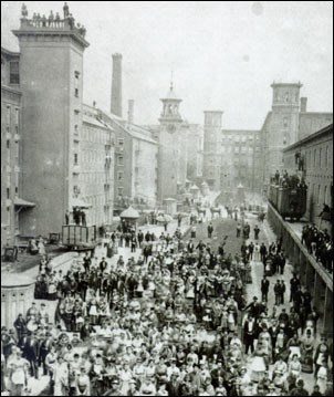 Photo of crowded street with industrial buildings. (Lowell Museum Collection/Lowell Historical Society)
