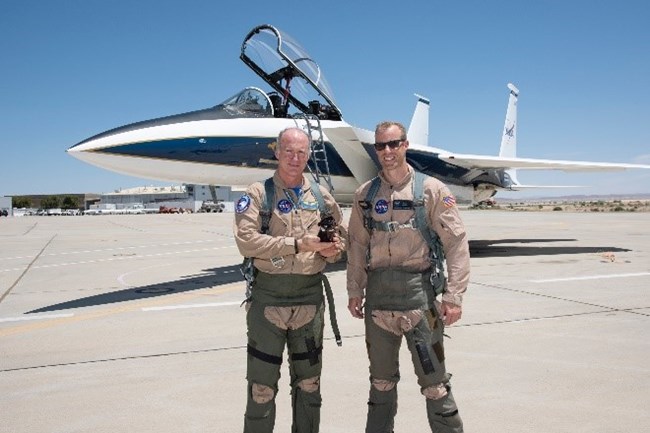 two pilots holding a toy dog