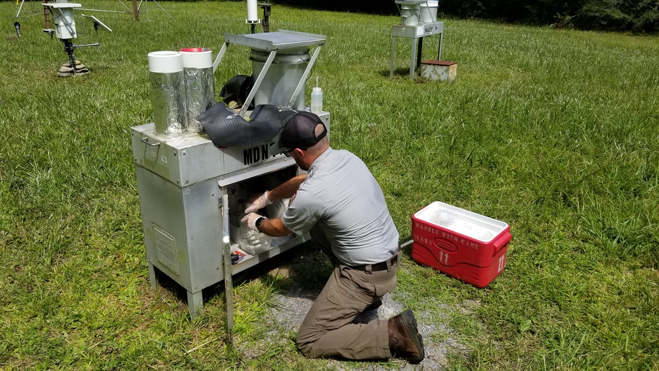 National Park Service staff collects water from a wet mercury deposition collector.