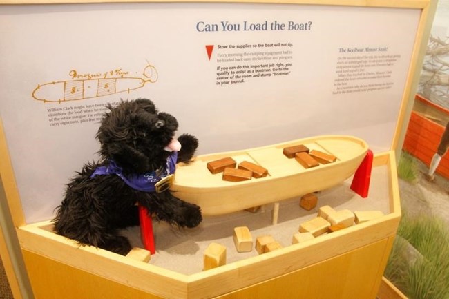 toy dog attempts to load the toy keelboat