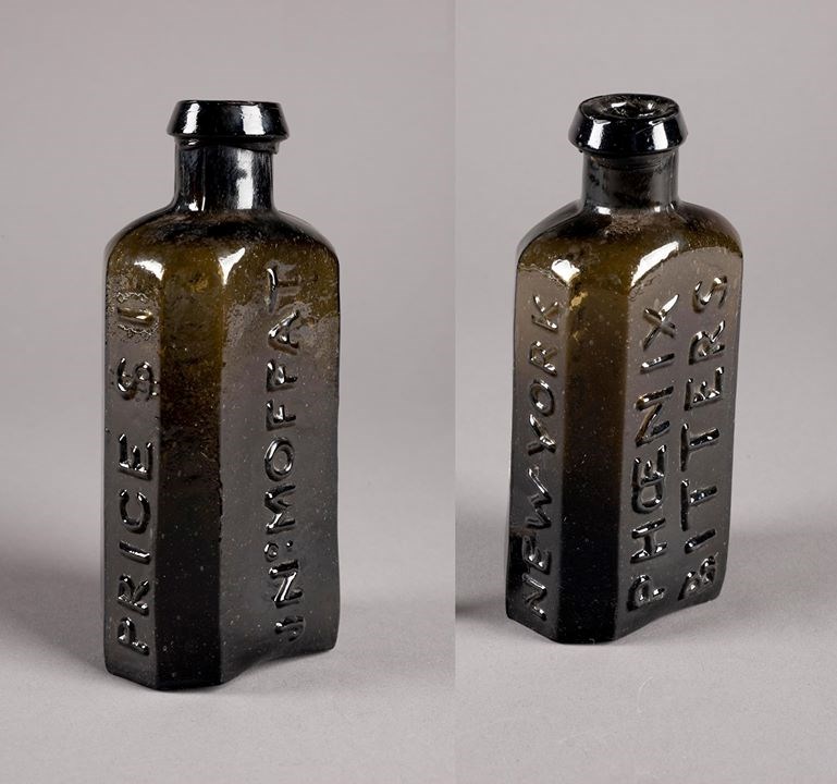 A front and back image of a dark glass medicine bottle.
